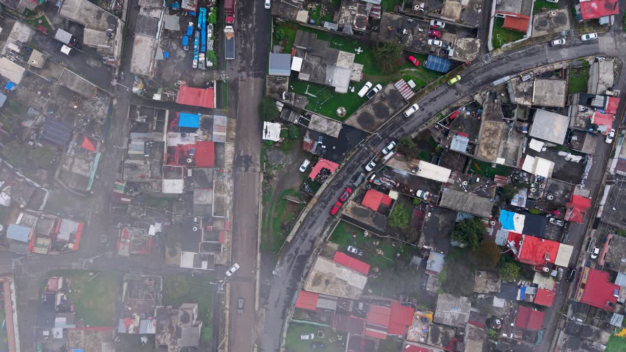 Aerial footage of drone descending through clouds over misty streets of town in Mexico on rainy day