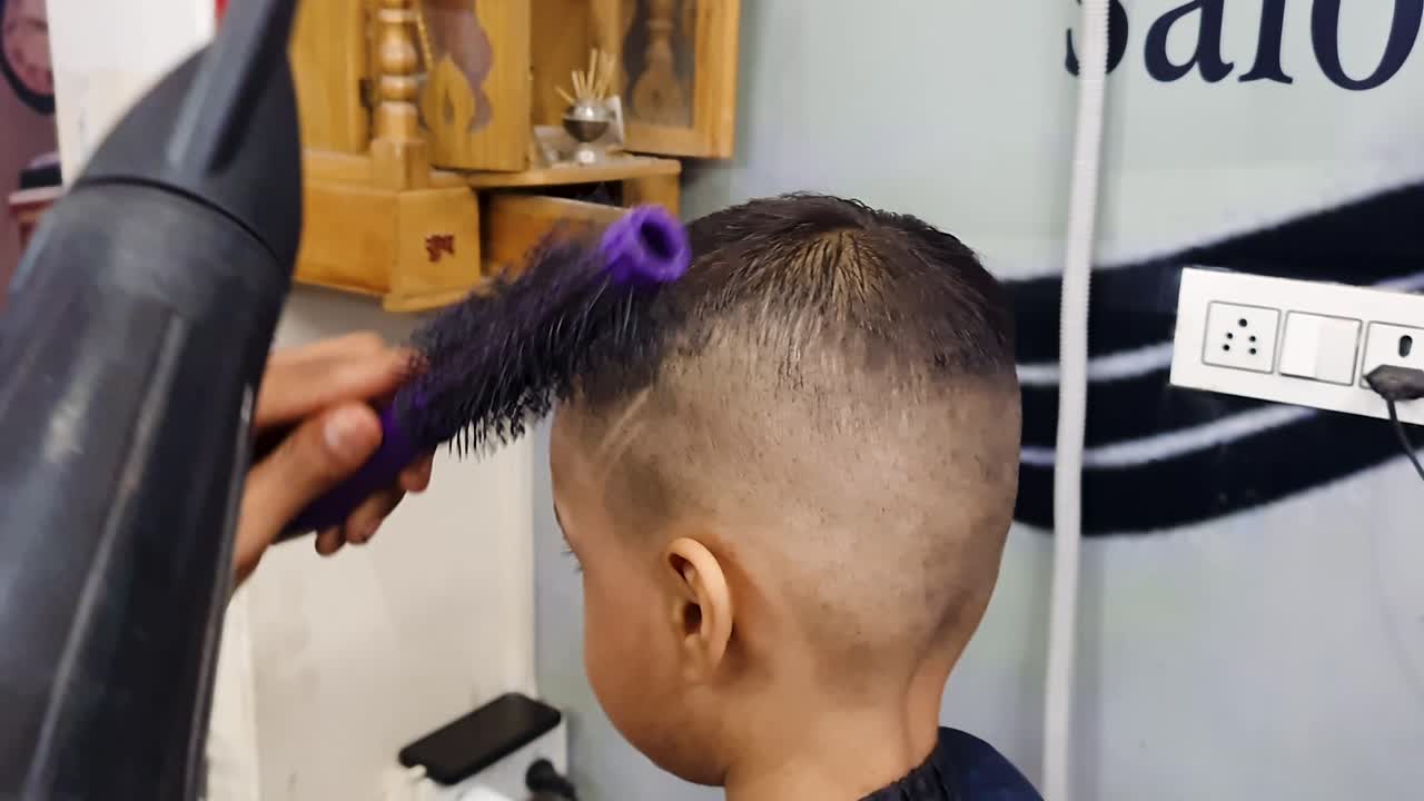 barber setting up kid stylish hair at salon at indoor