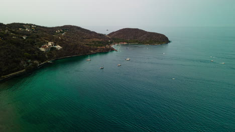 Vista-Aérea-De-Lapso-De-Tiempo-Con-Vistas-A-La-Isla-De-La-Playa-De-Ixtapa-México-Tráfico-De-Botes-Que-Llegan-Y-Salen-Por-El-Paisaje-Marino-Del-Océano