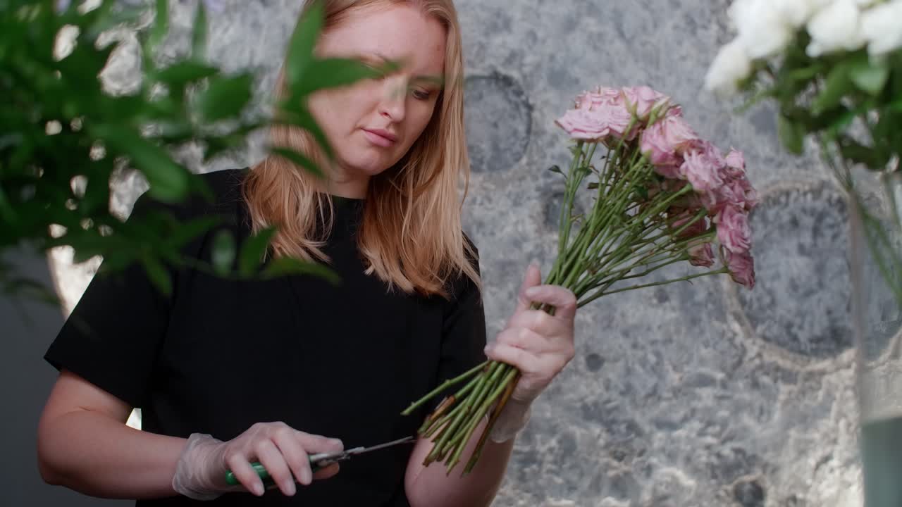 florista arreglando un ramo de rosas rosas