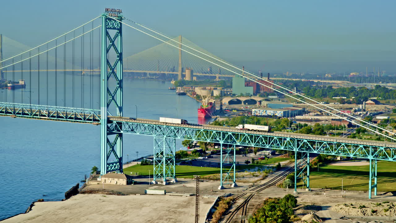 Cinematic aerial motion shot over Detroit River as a freighter approaches downtown