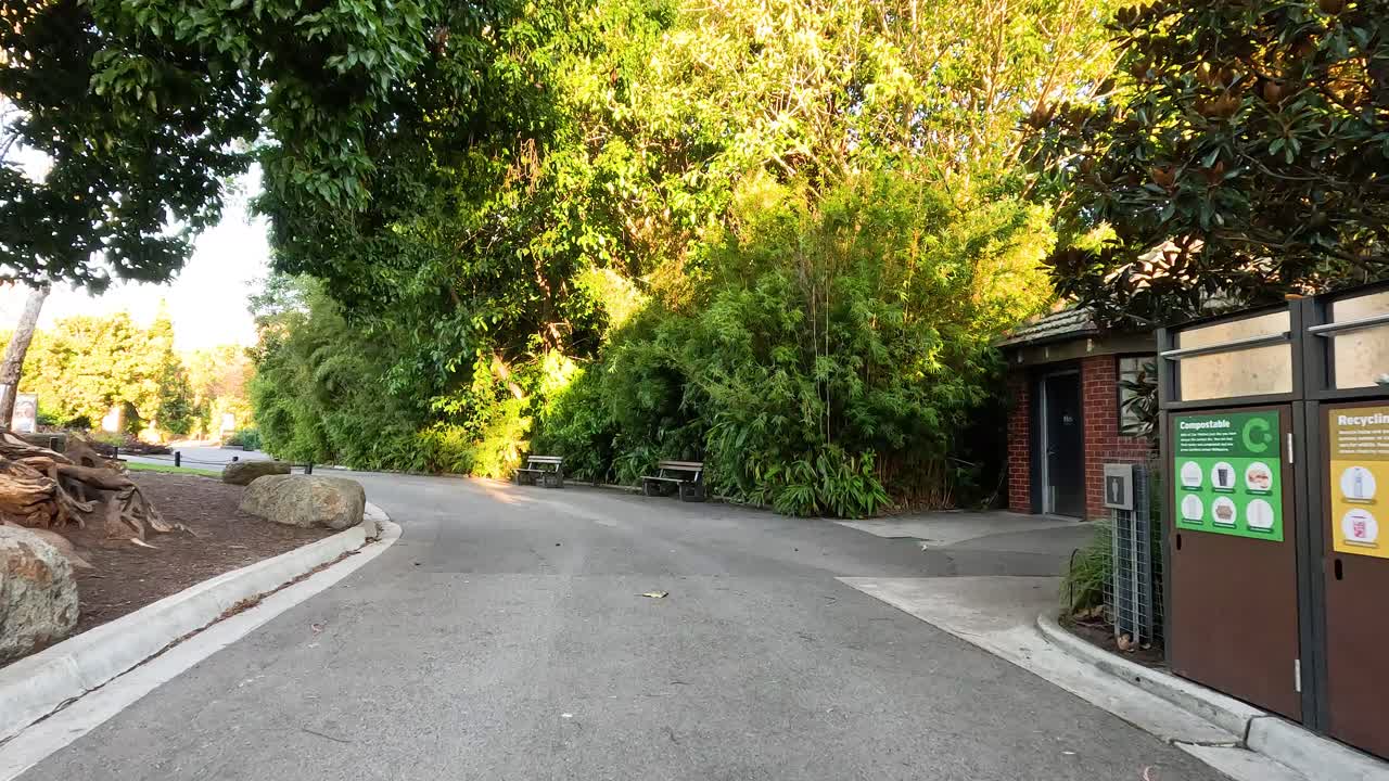sendero de parque con baños y estaciones de reciclaje