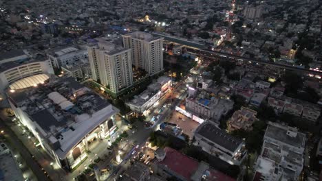 Vista-Aérea-De-La-Ciudad-De-Chennai-Por-La-Noche,-Con-Imágenes-Del-Teatro,-El-Centro-Comercial,-Las-Calles-Concurridas,-Los-Apartamentos-Residenciales-Y-El-Metro-De-La-Ciudad