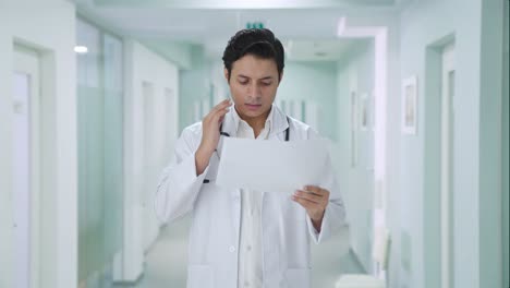 el médico indio tenso chequeando los informes médicos