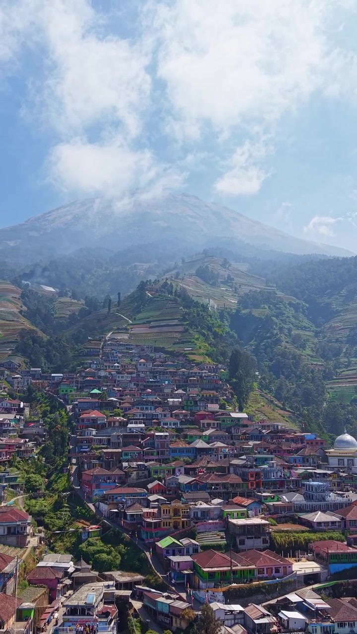 Vista aerea verticale di un colorato villaggio di montagna con sfondo montuoso, Nepal Van Java Indonesia, riprese con drone in formato verticale