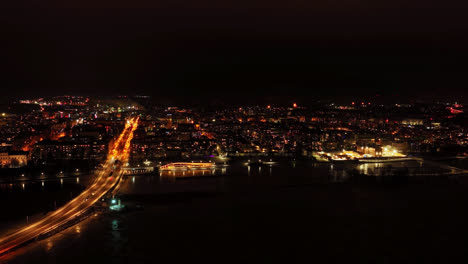 Hyperlapse-drone-shot-of-the-night-lit-seaside-of-Vaasa-city,-winter-in-Finland