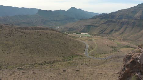 drone shot of road in the background with a big rock, gran canaria