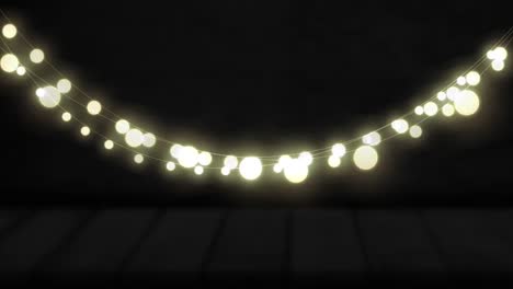 Animation-of-yellow-round-shaped-glowing-fairy-lights-hanging-against-copy-space-on-black-background