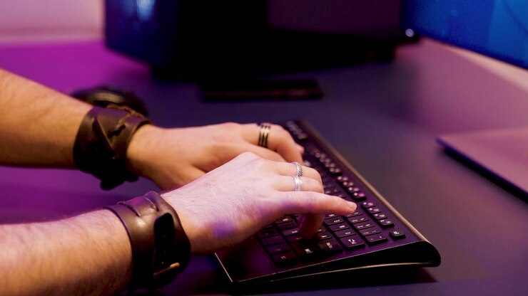 Close detail captures a gamer's hands controlling the keyboard