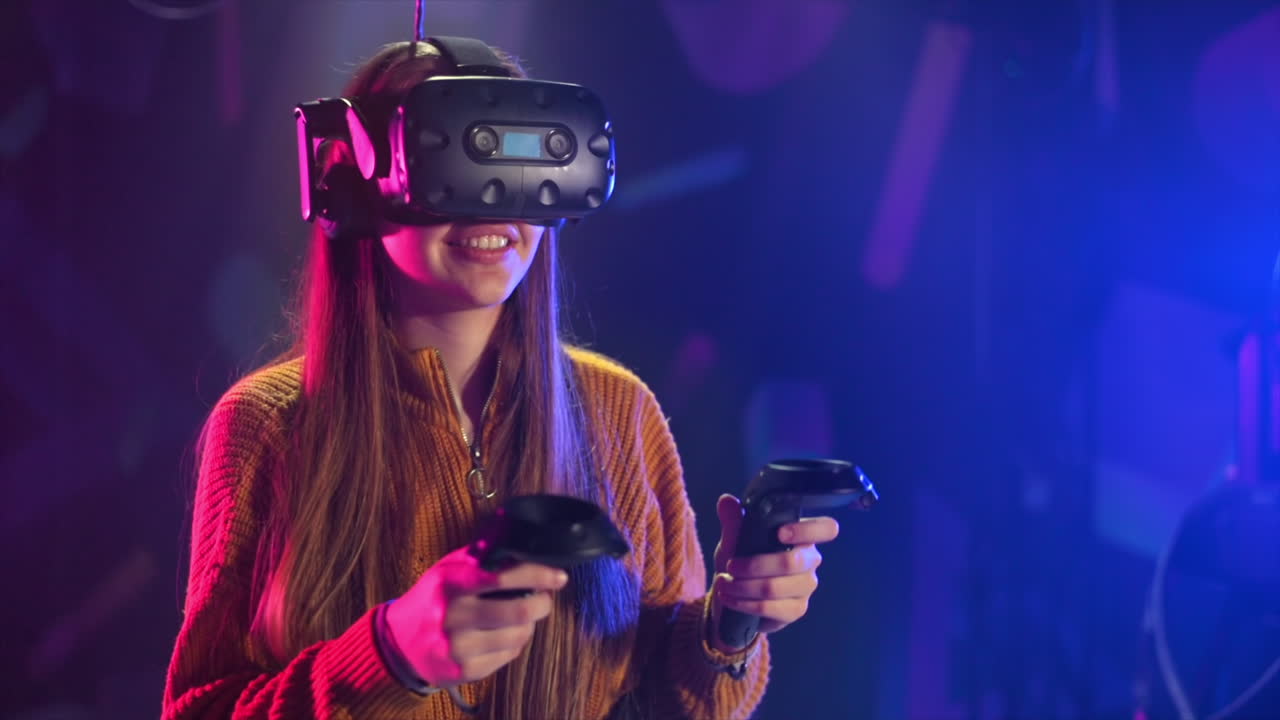 Una ragazza allegra e curiosa gioca su un tapis roulant VR con casco e controller. Rallentatore