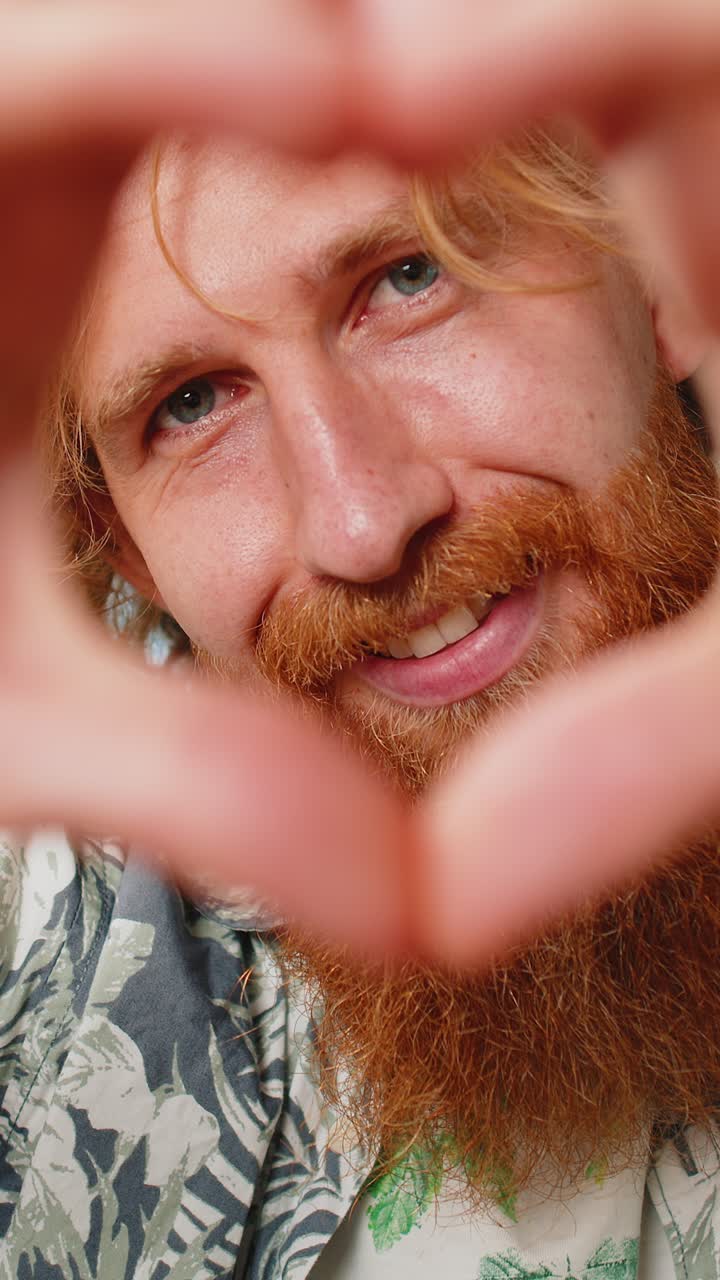 feliz hombre caucásico hombre hace símbolo de amor mostrando el corazón señal a la cámara expresar sentimientos románticos