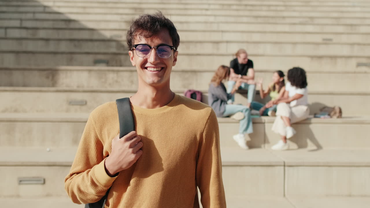 Сheerful European boy with glasses, male student with his friends in the