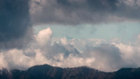 distant view of mount teide covered in snow, rising above the clouds, seen from gran canaria on a moody winter day. a breathtaking contrast of volcanic peaks and dramatic sky.