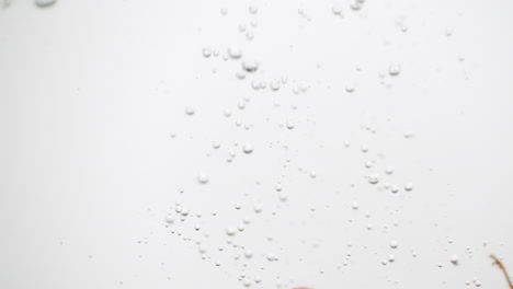 buch of grapes dropped into pure water with white background and rising bubbles