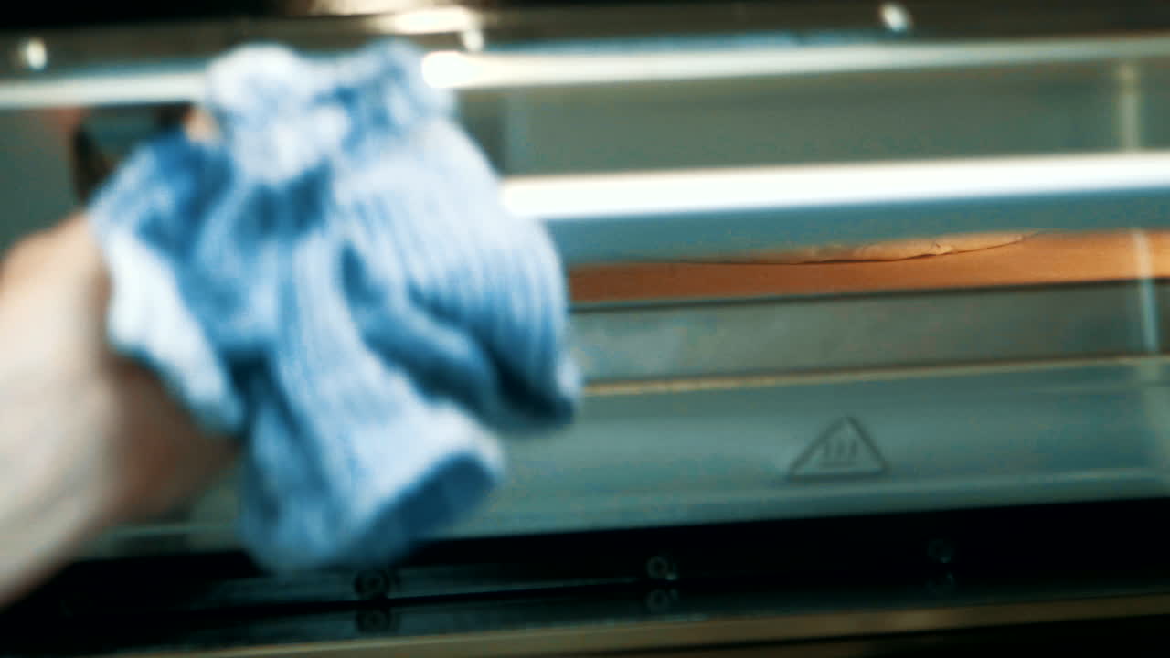 Placing pizza in big industrial kitchen oven