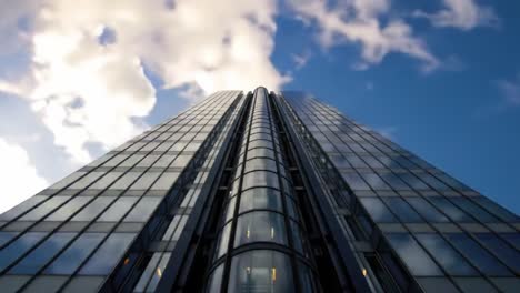 this striking skyscraper showcases innovative glass architecture as it stretches towards the sky. the scene is set in a bustling urban area under a bright blue sky with fluffy clouds.