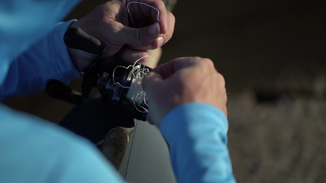 el pescador desenreda la línea de pesca en el carrete para atrapar peces depredadores.