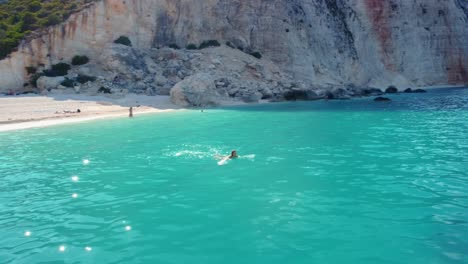 mujer nadando en el mar cerca de la playa de fteri en la isla de kefalonia, grecia