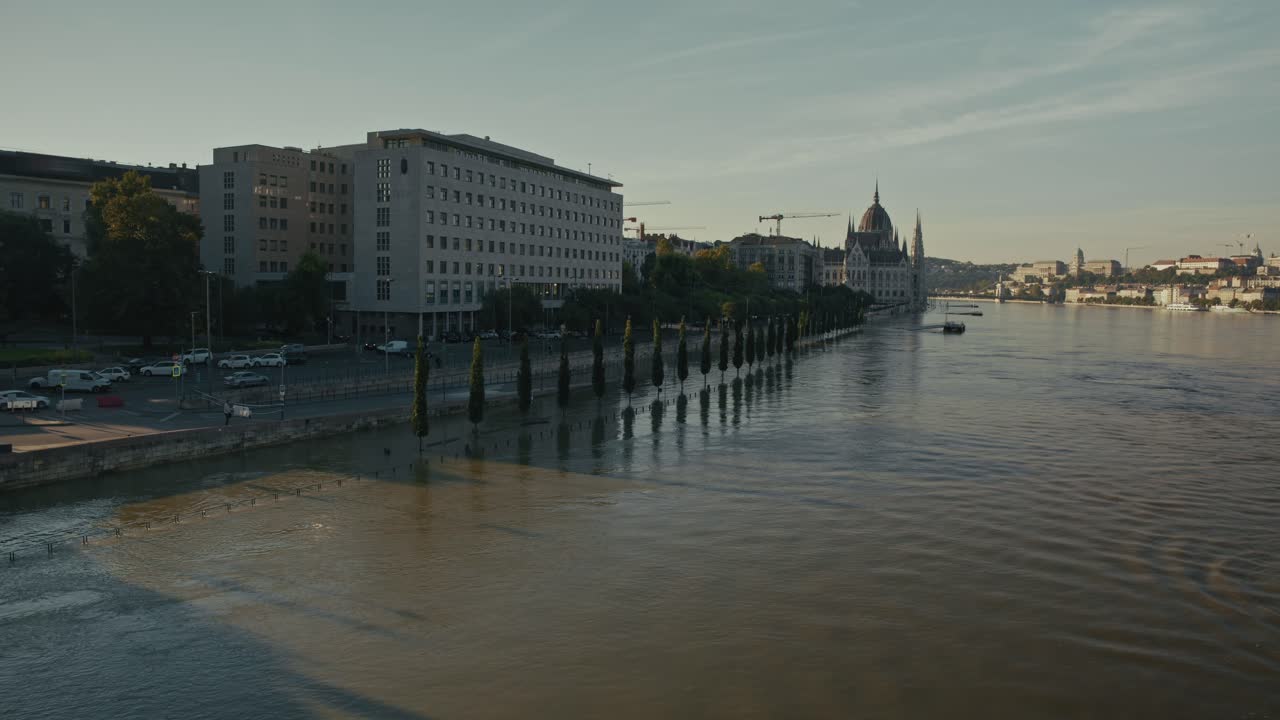 Flooded riverside road with buildings and the Hungarian Parliament in the distance, Budapest