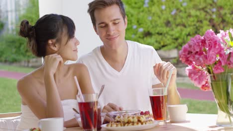 couple talking at breakfast table outside