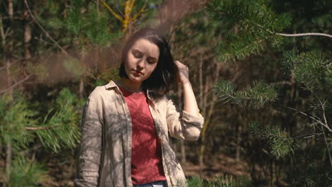 a young beautiful brunette girl walks through a pine forest