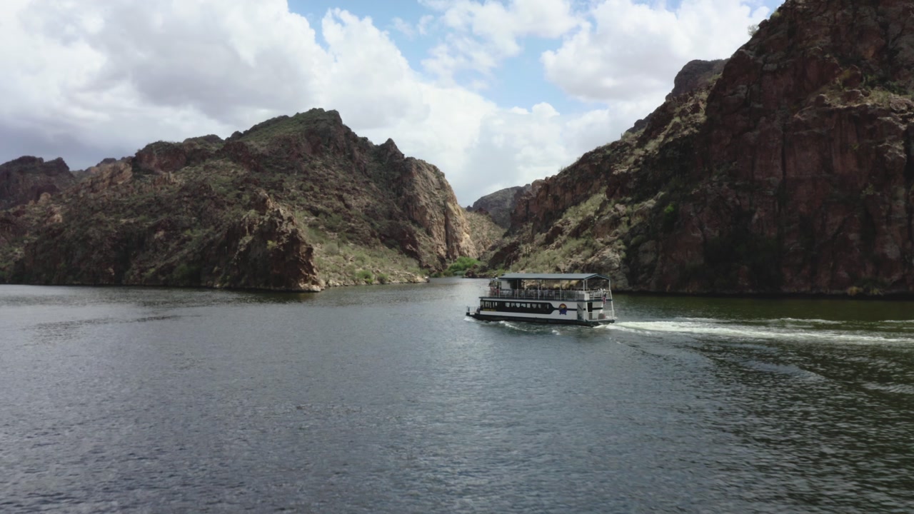 Ferry boat floats past southwestern mountains