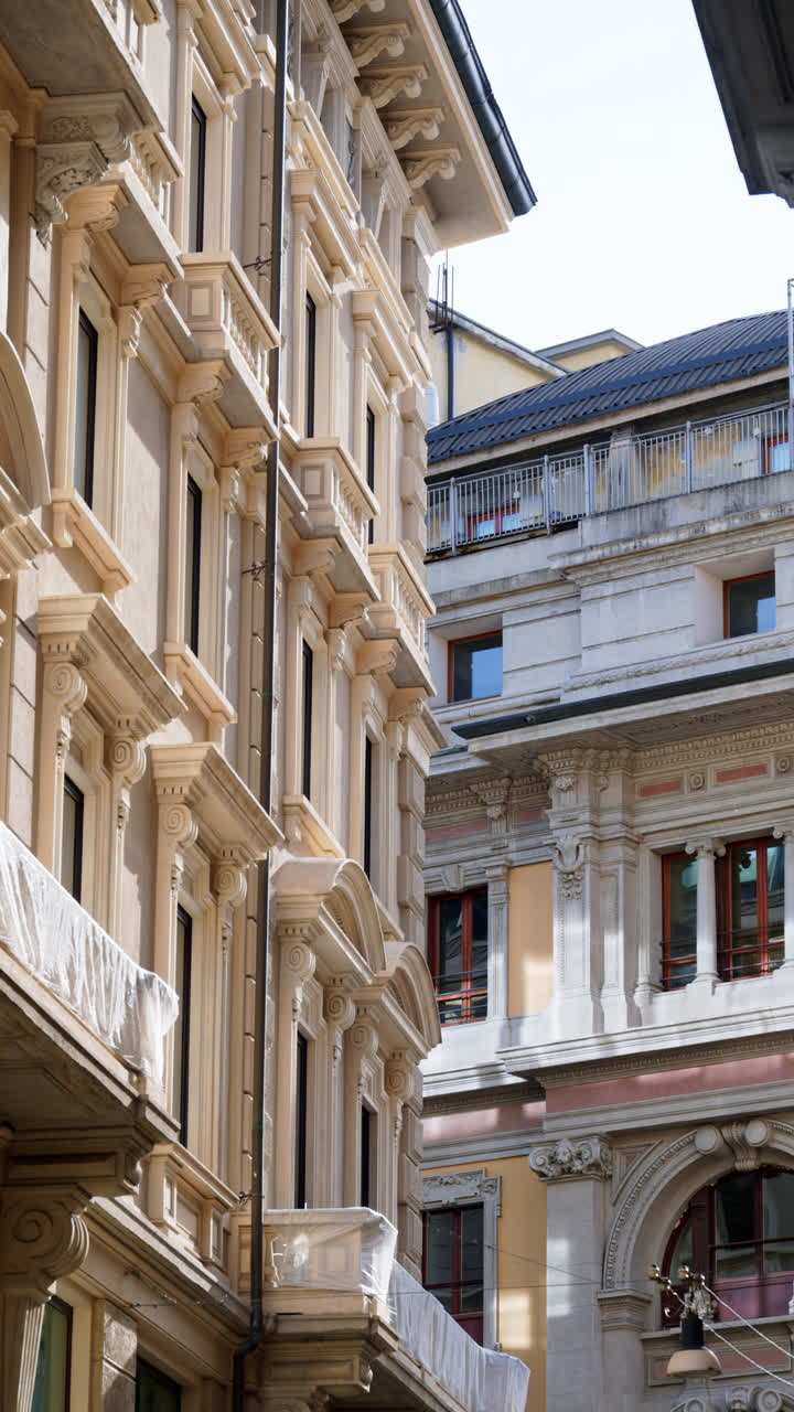 Veduta di edifici bianchi illuminati dalla luce del giorno a Milano, Italia. Verticale