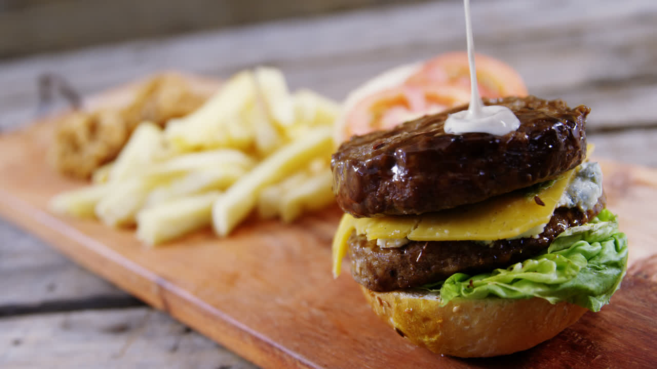 queso derretido cayendo sobre la hamburguesa en la bandeja