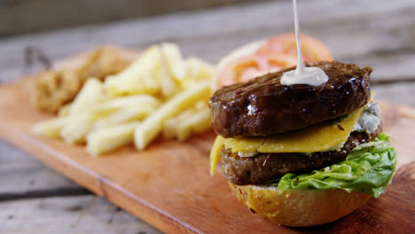 queso derretido cayendo sobre la hamburguesa en la bandeja