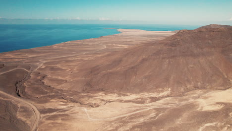 antena con amplias vistas costeras del paisaje árido con montañas escarpadas - playa de cofete, fuerteventura