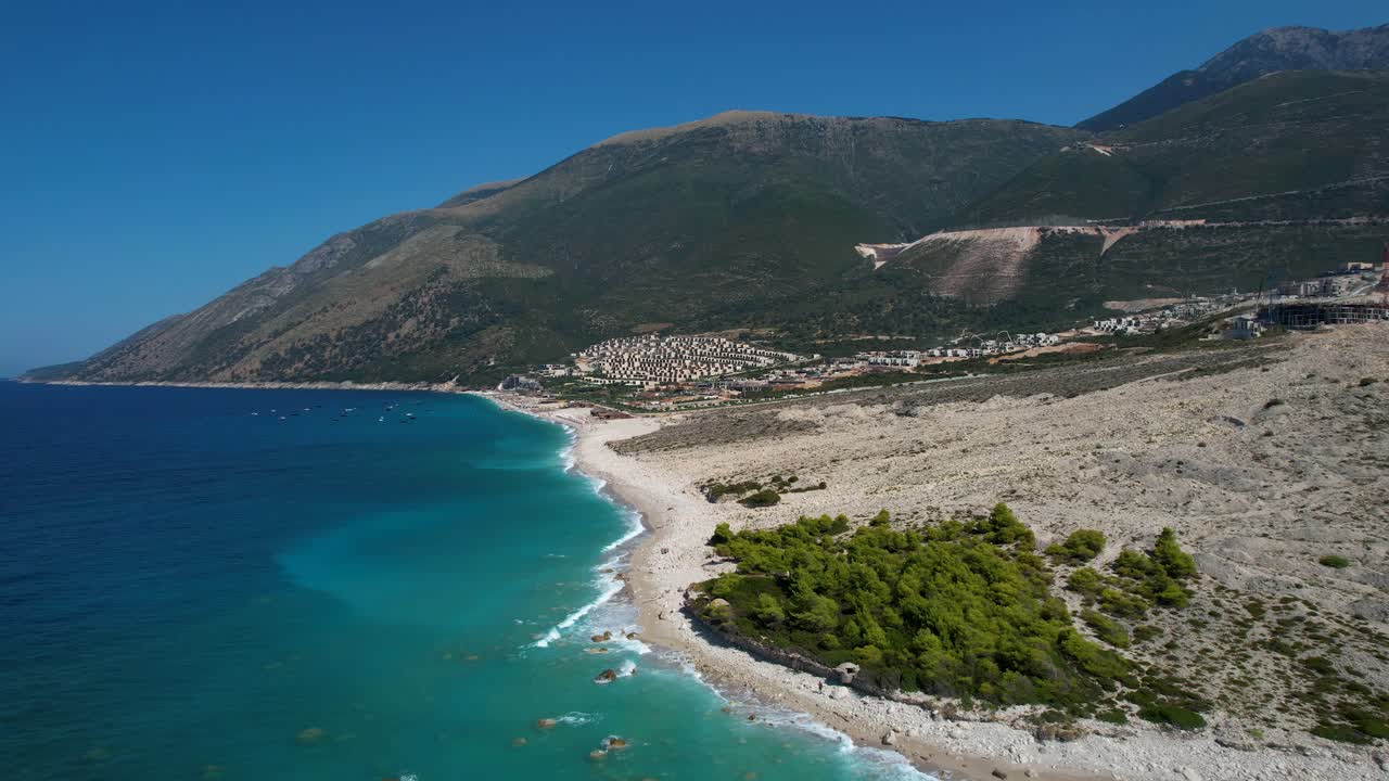 playa de guijarros prístina con aguas turquesas en el mar jónico amenazada por desarrollos de resorts de lujo, arriesgando la belleza natural de albania