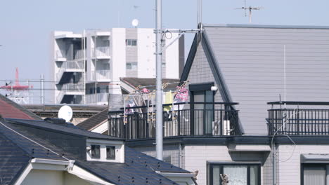 laundry on hanger at clothesline billowing in the wind at the balcony of a japanese house in tokyo, japan