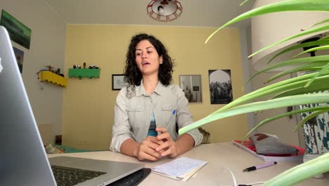 Mujer-De-Cabello-Rizado-En-Irán-Está-Grabando-Video-Para-Un-Seminario-Web-De-Clase-En-Línea-En-Teherán,-Irán,-Idioma-Persa-Y-Concepto-De-Aprendizaje-En-Un-Curso-En-Línea,-Trabajo-De-Clase-En-Casa-Y-Decoración-En-Una-Computadora-Portátil-De-Diseño-Amarillo