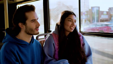 una pareja joven sentada en el autobús.