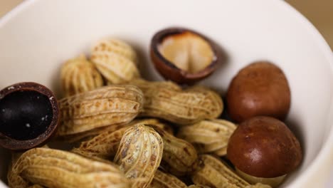 peanuts and nuts arranged in a white bowl