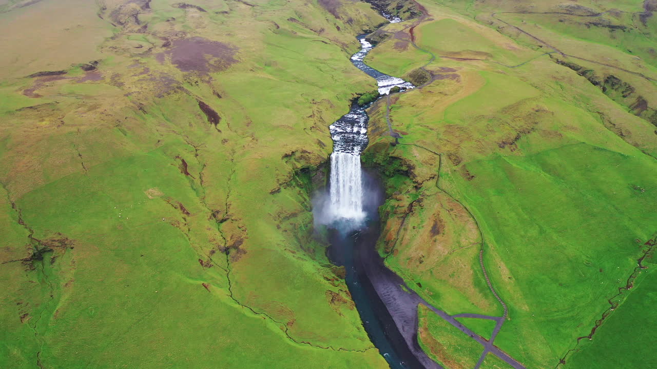 cascada de skogafoss durante el verano - video aéreo de retroceso - carretera de circunvalación islandia en 4k
