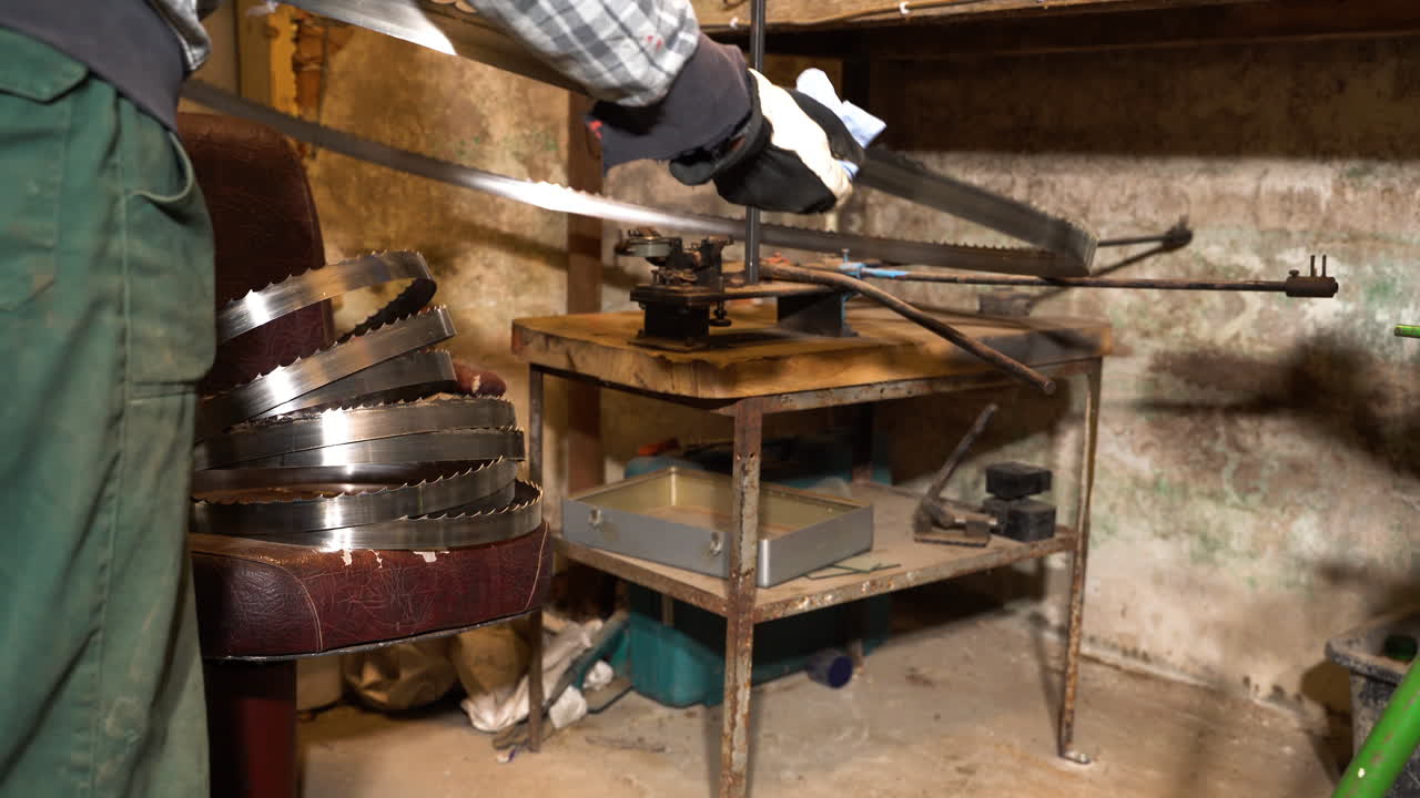 limpieza mecánica de la banda de la sierra de cinta y se instala en la mesa del taller para el plegado de caminos