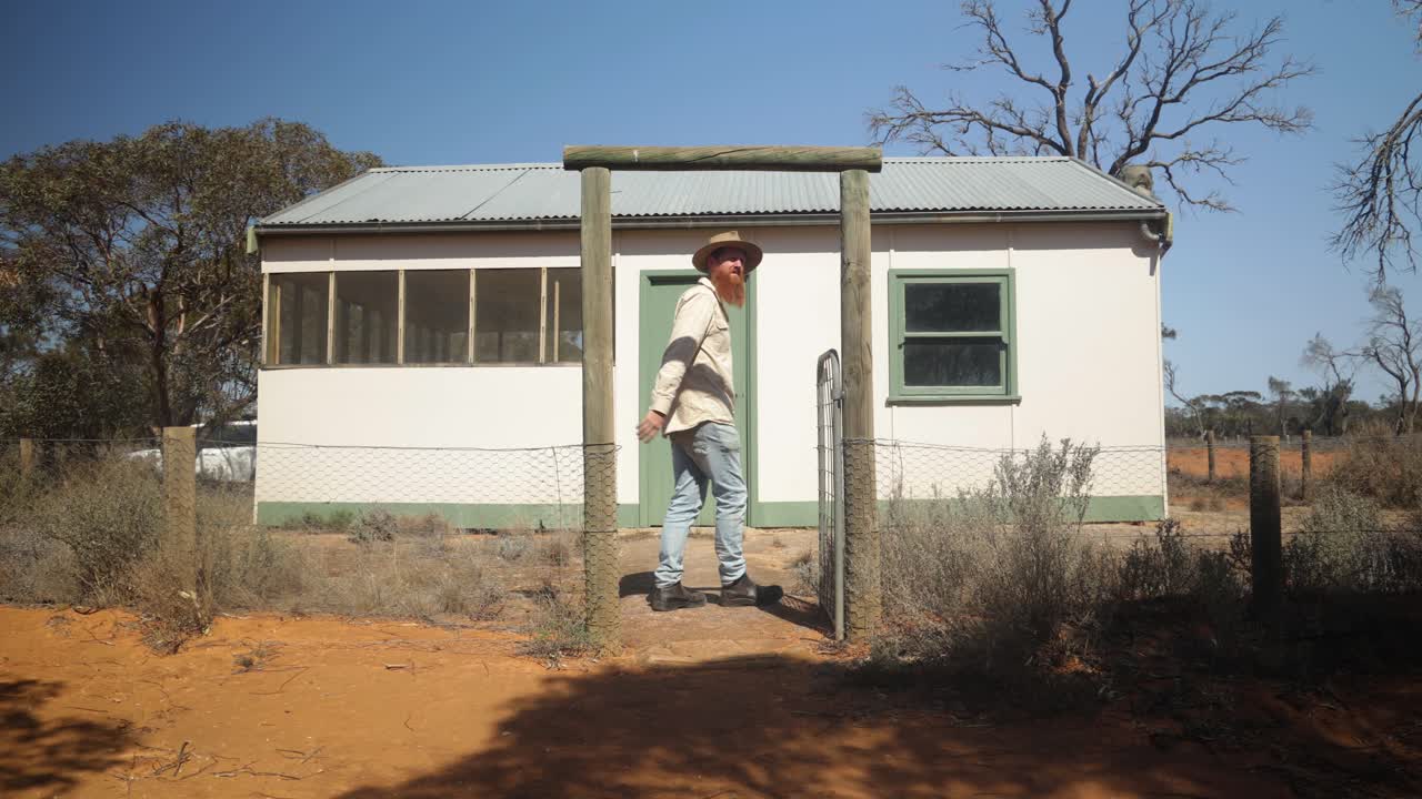 A man walks into a historic hut in the Australian outback.