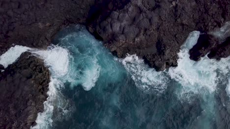 aerial top down of ocean waves crashing in rock cliff forming natural pool in tenerife island los gigantes spain drone amending