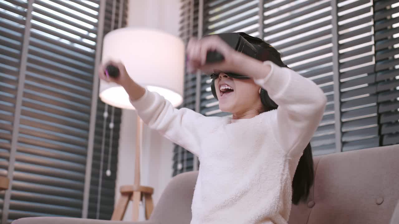 encantadora chica asiática jugando realidad virtual vr disfrutando de videojuegos alegres en un sofá en la sala de estar en casa