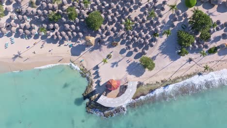 touristic village on playa dominicus beach, bayahibe in dominican republic. aerial top-down orbiting