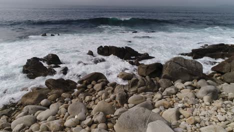 olas chocando contra las rocas del mar
