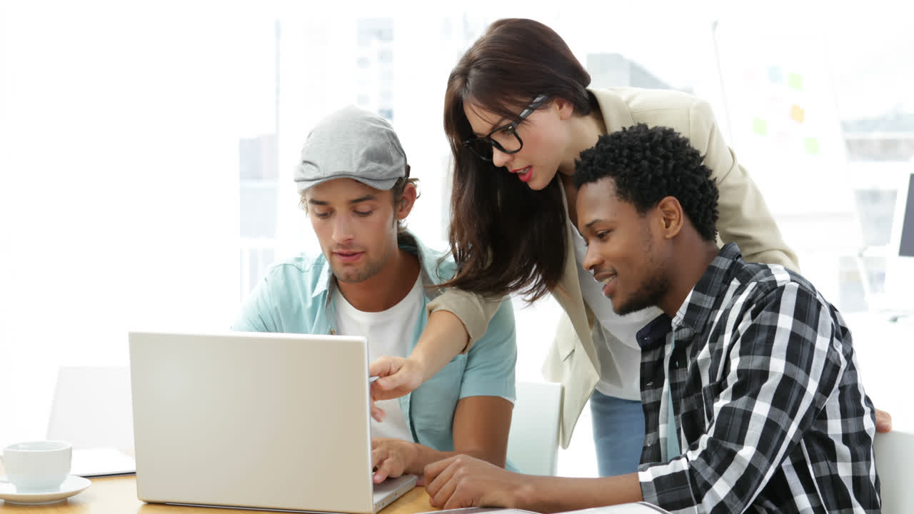 empleados trabajando juntos en la computadora portátil en el escritorio