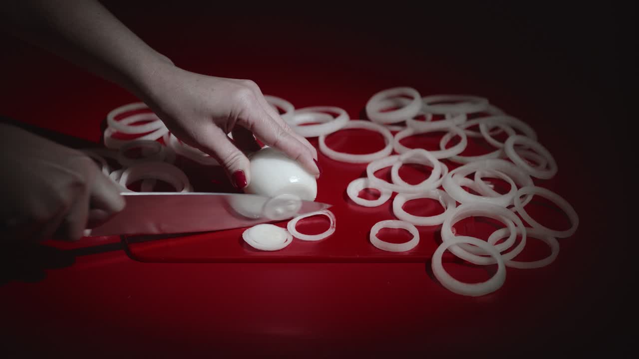 Wide view of woman hands cutting white onion into slices.Female slicing onion.