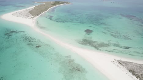 Cayo-de-agua-in-los-roques-with-a-tilt-down-motion-over-turquoise-waters,-aerial-view