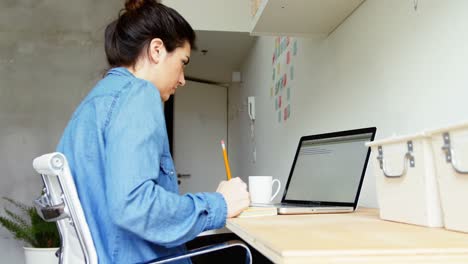 mujer ejecutiva escribiendo en notas adhesivas en el escritorio