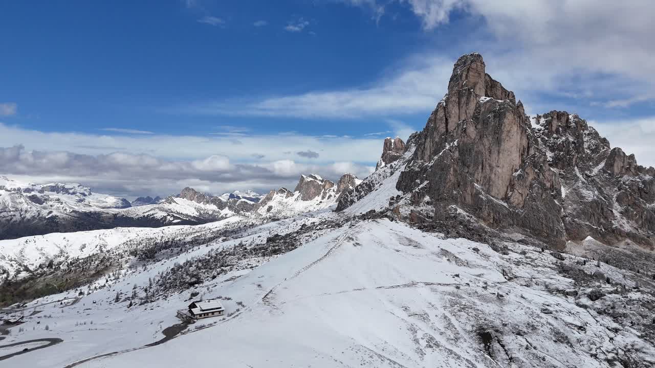 Snowy Passo Giau with rugged peaks and a small hut in the Dolomites