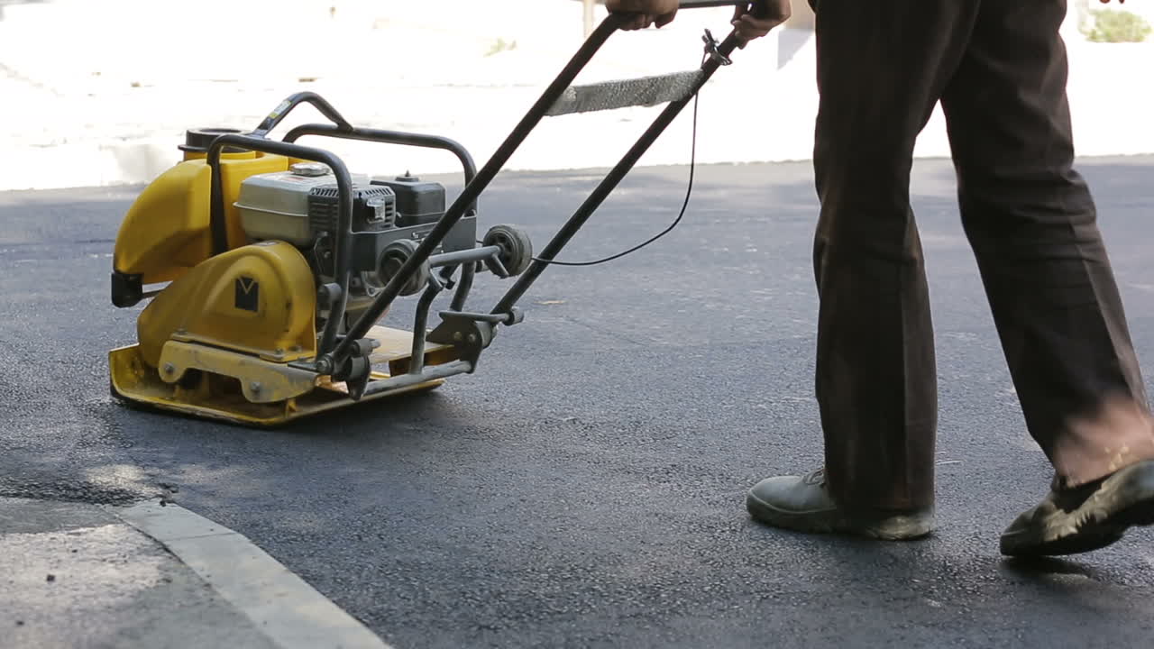 Asphalting paver during road roller at work on the road construction