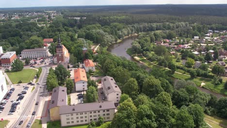 An-aerial-view-of-Valmiera-city,-showcasing-its-blend-of-urban-and-natural-elements