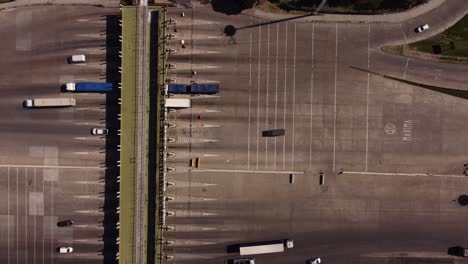 toma aérea de arriba hacia abajo de los camiones que llegan al peaje después de conducir por la autopista en buenos aires - pago del peaje en argentina
